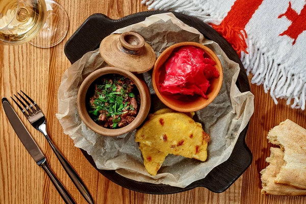 Лобіо з горіхами, маринованою червоною капустою та смаженою сулугуні на дерев'яному столі — стокове фото
