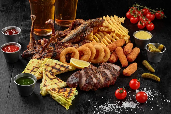 Bier-Set mit Hühnern, Schweinefleisch, Fisch, Käsesticks, Zwiebelringen, Pommes und Burritos — Stockfoto