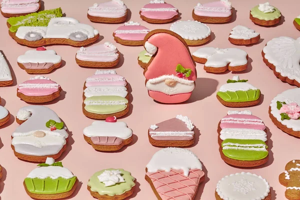 Sugar powlekane pierniki gnome wśród ciasteczek imbirowych na różowym tle — Zdjęcie stockowe