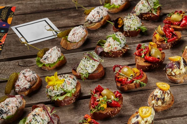 Bruschettas com creme de queijo, salmão, presunto e legumes — Fotografia de Stock