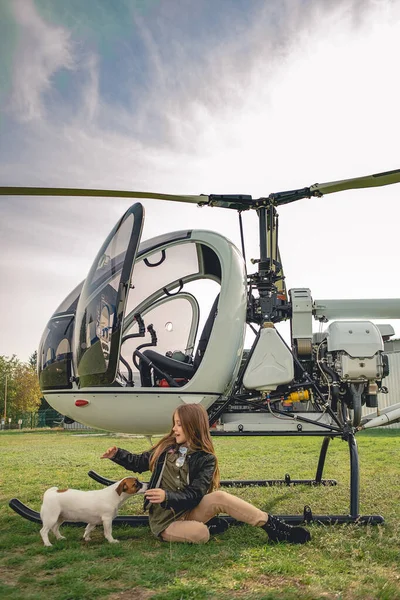 Vidám tini lány játszik kiskutya közelében helikopter — Stock Fotó