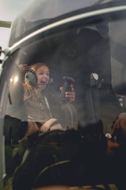 Helikopterde yardımcı pilot koltuğunda oturan heyecanlı genç kız.