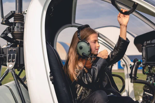 Koncentrált tizenéves lány pilóta headset ül helikopter pilótafülkében — Stock Fotó