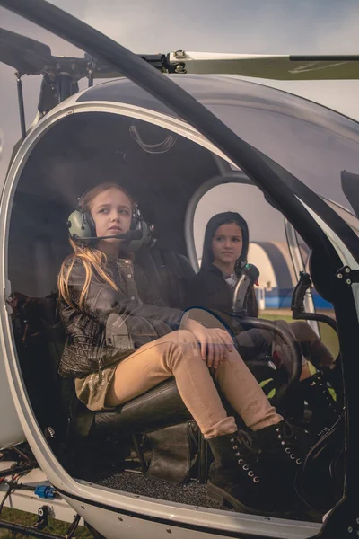 Két álmodozó tinilány pilótafülkéken a helikopterpilótafülkében. — Stock Fotó