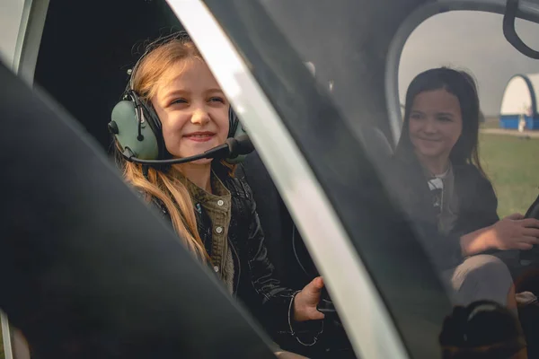 Mosolygós tini lány pilóta headset ül helikopter pilótafülkében — Stock Fotó
