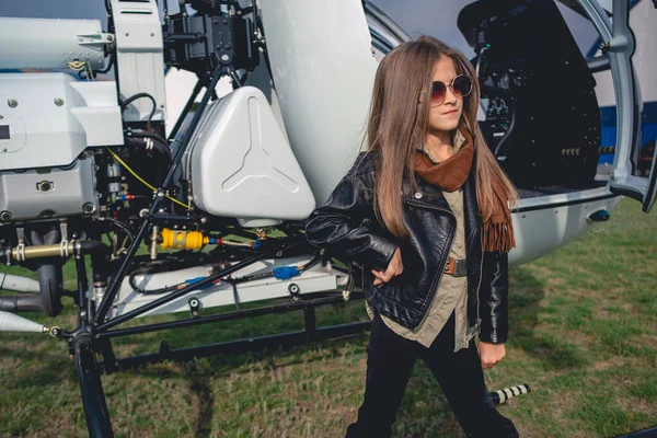 Magabiztos tini lány napszemüvegben áll nyitott helikopter mellett — Stock Fotó