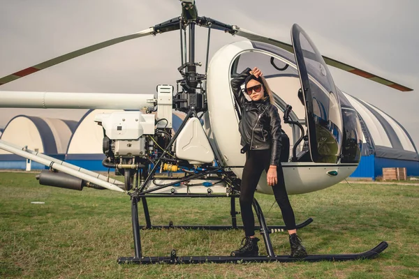 Tween lány fekete ruhában áll a helikopter mellett — Stock Fotó