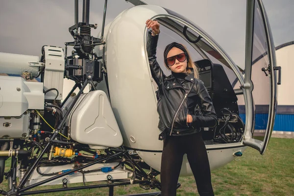 Magabiztos tizenéves lány támaszkodik nyitott pilótafülkében helikopter — Stock Fotó