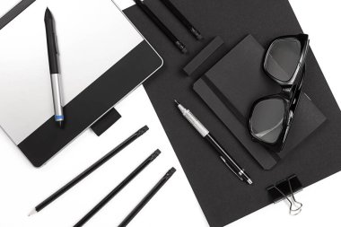 Klipleri, kalem, bardak düz ile boş not etmek yatıyordu.