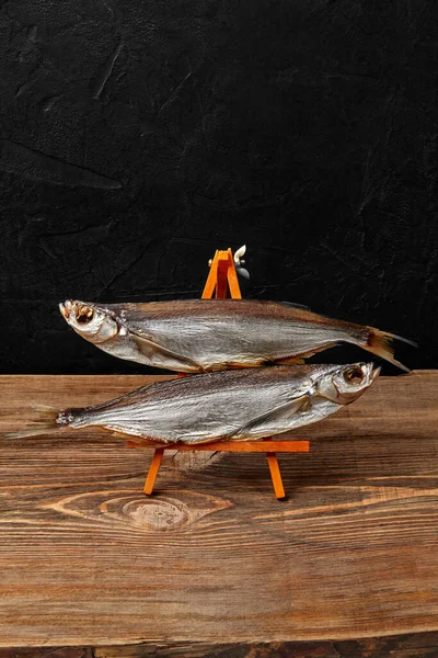 Deux sabrefish séchés à l'air sur support de service sur fond noir — Photo