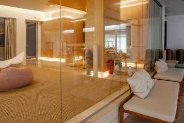 Geniş, açık, cam duvarlı bir dairede lüks oturma alanları.