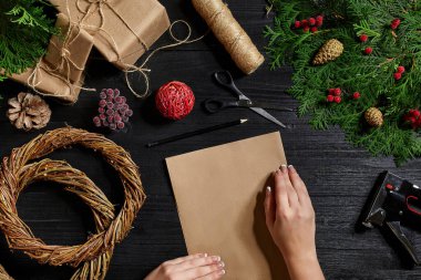 En iyi eller görünümünü yeni yıl hediyesi sarın. Yemeği hediyeler ve verilirse, şube ve ahşap masa üstünde alet çeki düzen vermek.