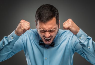 Portrait angry upset young man in blue shirt, butterfly tie clipart