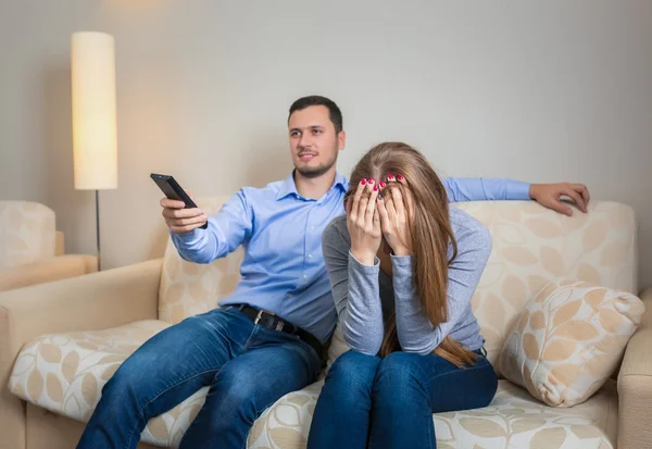 Retrato de pareja sentada en un sofá viendo la televisión . — Foto de Stock