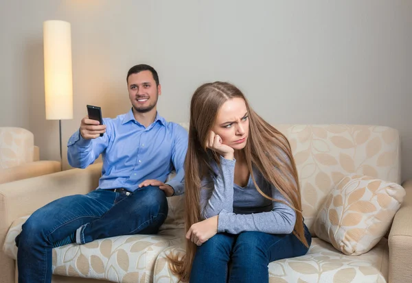 Portrait of couple sitting on sofa watching television. — Stock Fotó