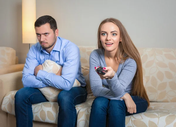 Portrait of couple sitting on sofa watching television. — Stock Fotó