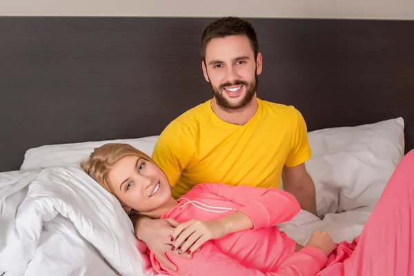 Young lovely couple lying and have fun in a bed — Φωτογραφία Αρχείου