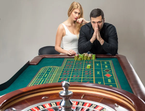 Mężczyźni z kobietami gry ruletka w kasynie. — Zdjęcie stockowe