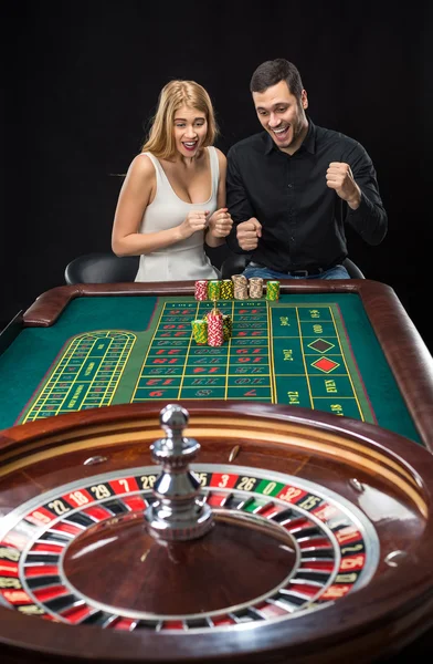 Άνδρας και γυναίκα πανηγυρίζουν στο τραπέζι της ρουλέτας στο καζίνο — Φωτογραφία Αρχείου
