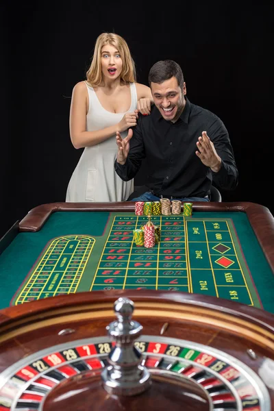 男と女のカジノでルーレットのテーブルで応援 — ストック写真
