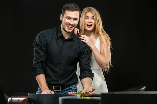庆祝在轮盘赌桌在赌场赢的年轻夫妇. — 图库照片