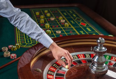 Rulet tekerleği ve krupiye casino beyaz topu eliyle