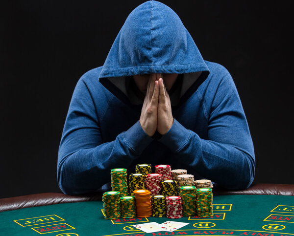 Портрет профессионального игрока в покер, сидящего за покерным столом
