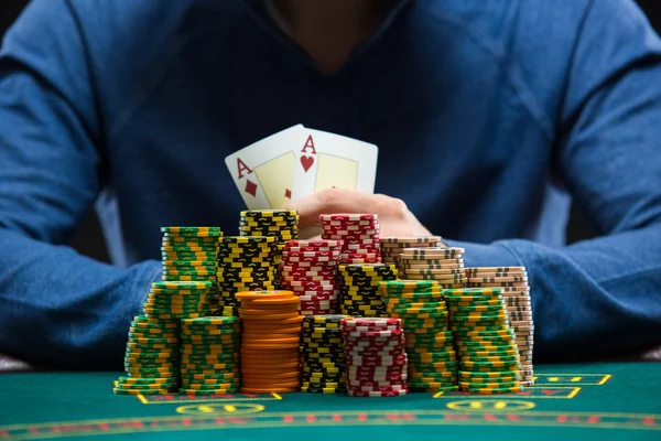 Poker player showing a pair of aces. Closeup