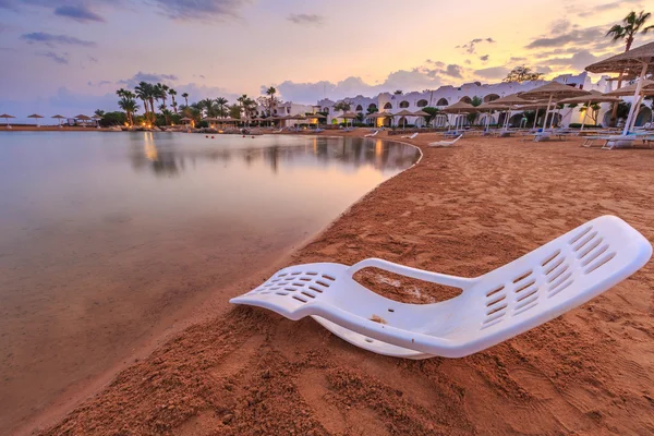 Landskap av lonely beachchair nära havet och vacker solnedgång. — Stockfoto