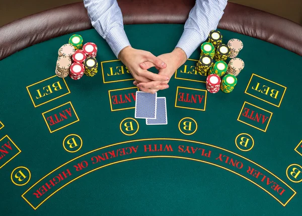 Closeup of poker player with playing cards and chips — Stock Photo, Image
