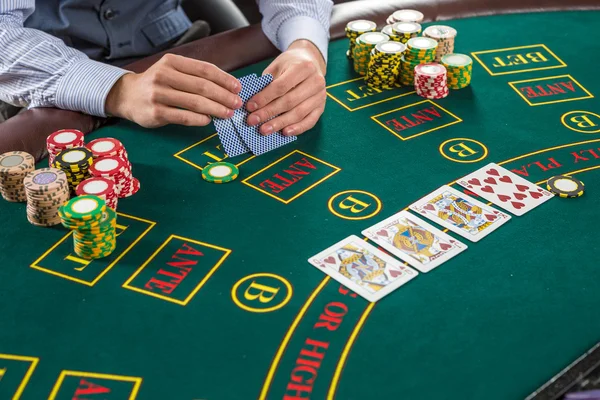 Nahaufnahme eines Pokerspielers mit Spielkarten und Chips — Stockfoto