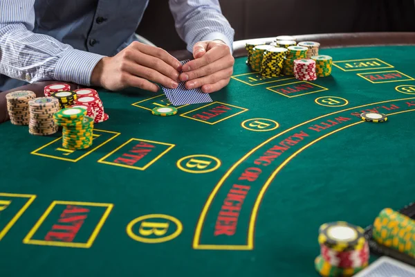 Nahaufnahme eines Pokerspielers mit Spielkarten und Chips — Stockfoto