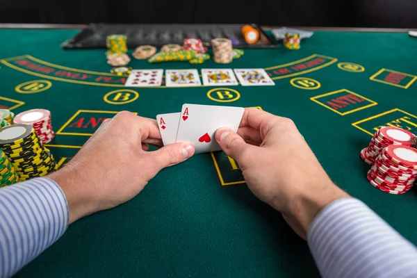 Jogador de poker masculino levantando os cantos de duas cartas ases — Fotografia de Stock