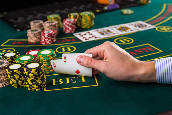 Jogador de poker masculino levantando os cantos de duas cartas ases — Fotografia de Stock