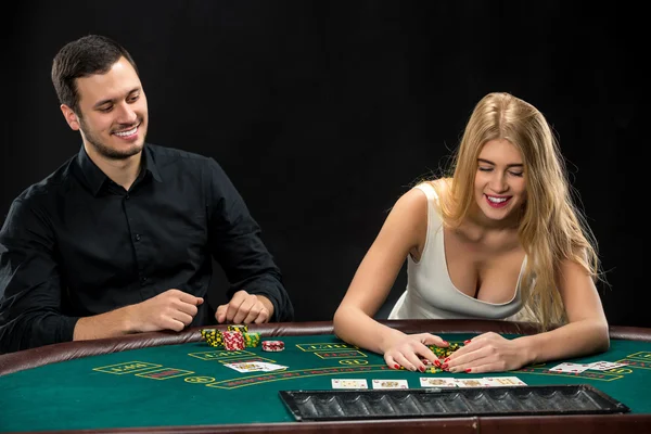 Junges Paar pokert, Frau nimmt Pokerchips nach dem Gewinn — Stockfoto