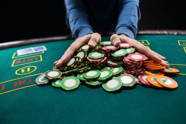 Poker player going all-in pushing his chips forward — Stock Photo, Image