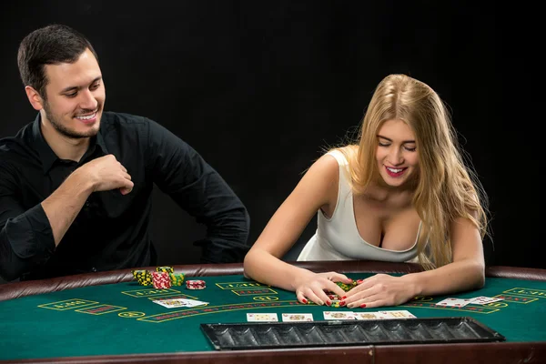 Junges Paar pokert, Frau nimmt Pokerchips nach dem Gewinn — Stockfoto