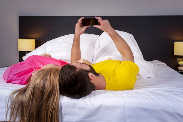 Молодая пара лежит на кровати на спине — стоковое фото