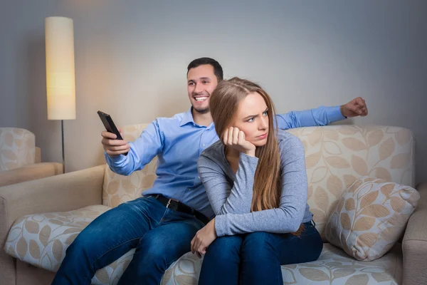 Retrato de casal sentado no sofá assistindo televisão . — Fotografia de Stock