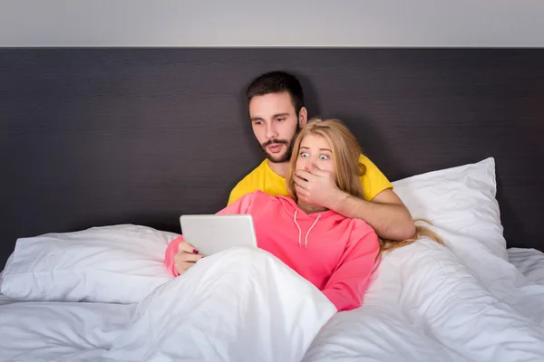 Jovem casal doce na cama assistindo algo em Tablet Gadget — Fotografia de Stock