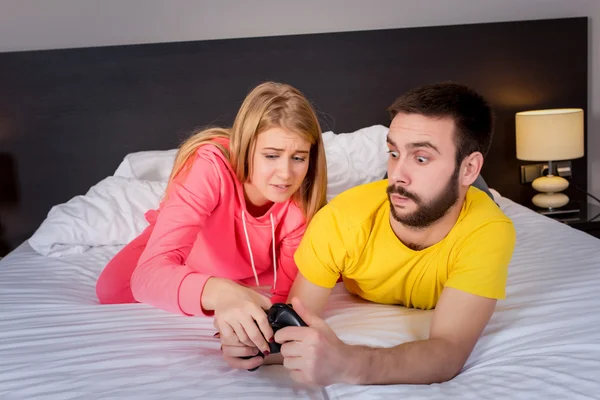 Young couple having playing videogames in bed — Stock Fotó