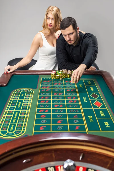 Männer mit Frauen spielen Roulette im Casino. — Stockfoto
