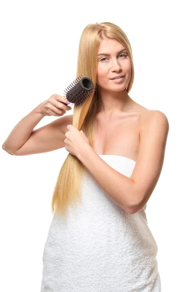 Jovem mulher em uma toalha escovando o cabelo . — Fotografia de Stock