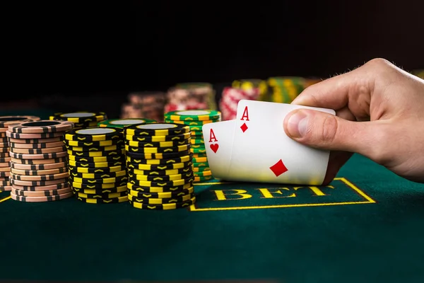 Jogador de poker masculino levantando os cantos de duas cartas ases — Fotografia de Stock