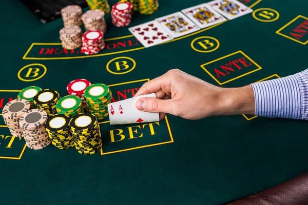 Männlicher Pokerspieler hebt die Ecken zweier Karten-Asse — Stockfoto