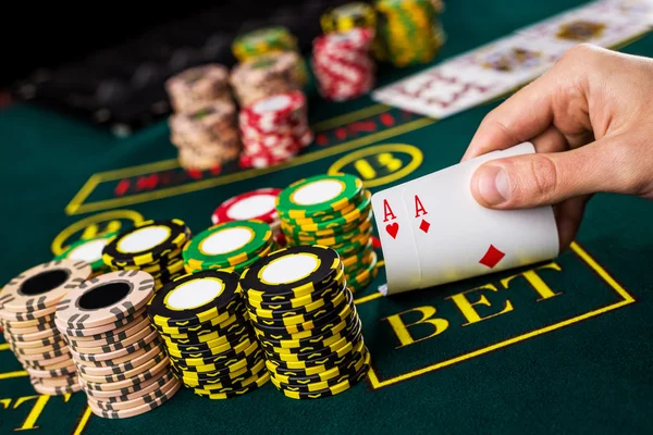 Manliga pokerspelare lyft hörnen av två kort ess — Stockfoto