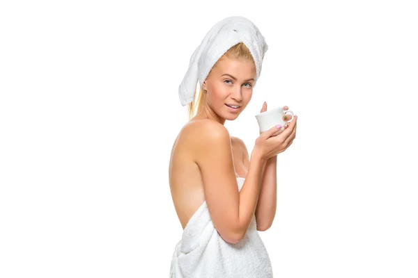 Jonge vrouw in de handdoek drinkt uit een kopje — Stockfoto