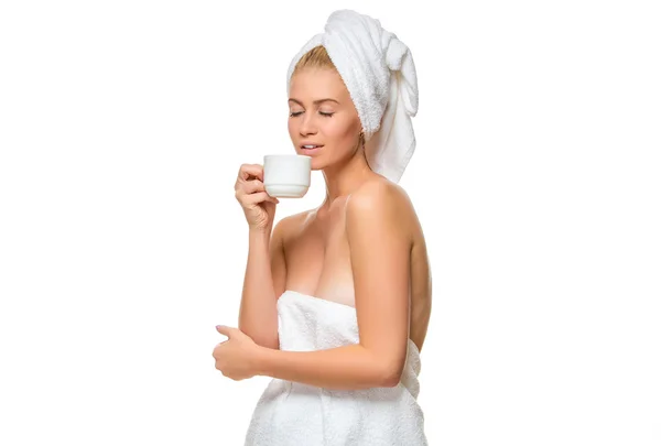 Young woman in towel drinks from a cup — Stock Photo, Image