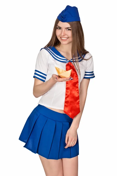 Dívka v kostýmu námořníky. Do rukou drží papírovou loďku. — Stock fotografie