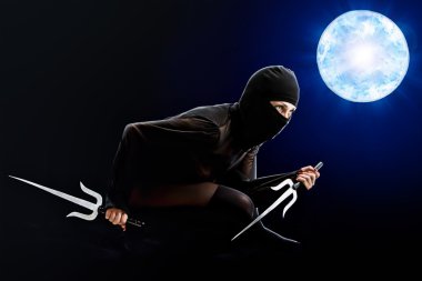 Ninja Kız ay zemin karşı ellerinde bıçaklarla